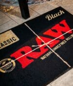 RAW Black Matte mit rotem RAW Logo 80x120cm auf Fliesenboden