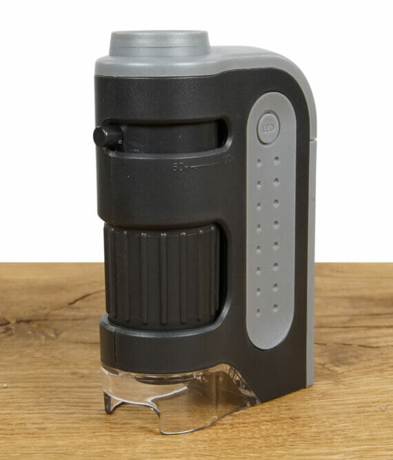 Taschenmikroskop Carson MicroBite Plus MM-300 auf einem Holzbrett