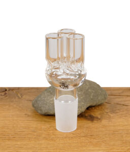 Dreifach-Adapter aus Glas für Bongs mit Schliff, stehend auf Naturstein und Holztisch.
