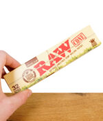 Hand hält eine geschlossene Packung RAW Organic Hemp Cones King Size 32er Pack aus naturbelassenem Hanfpapier
