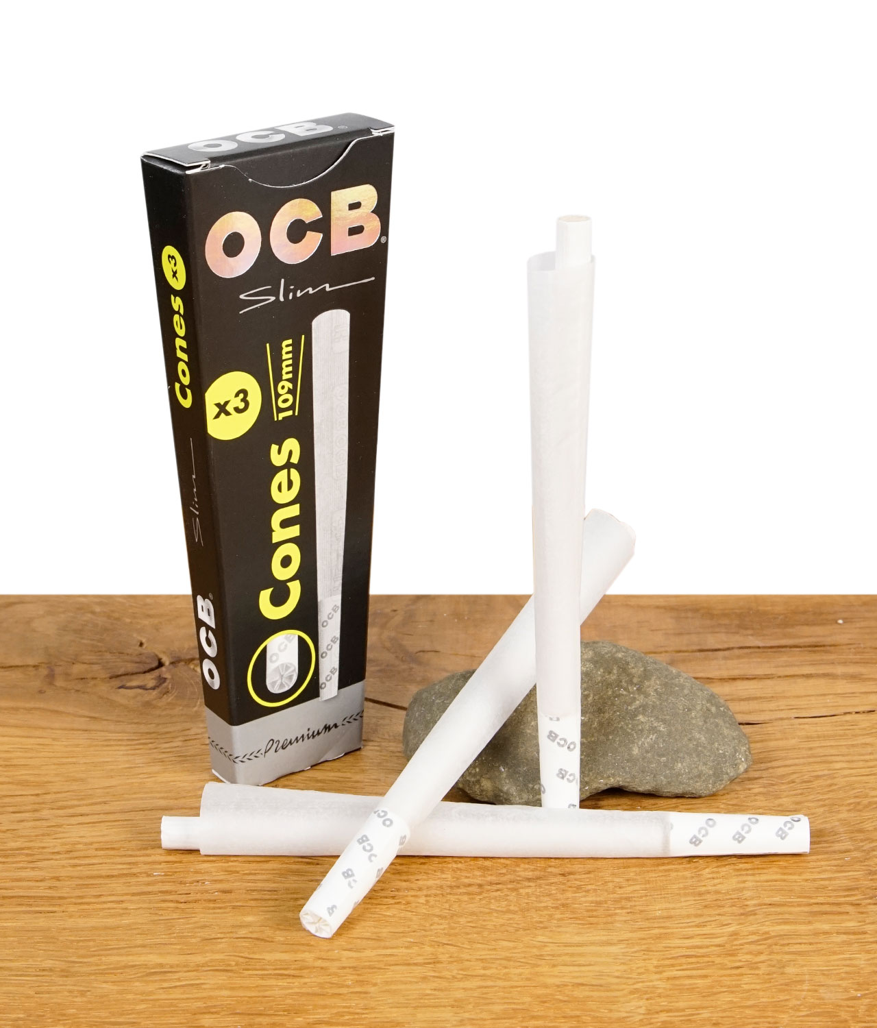 ocb-slim-cones-3er-pack-jpg OCB Premium Cones Slim 3er Pack mit drei vorgedrehten Cones und schwarzer Verpackung auf Holztisch