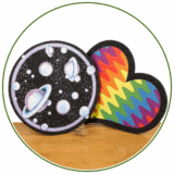 Dab Mats sind Untersetzer für Glas im bereich Dabbing und Glasbongs. Oft sind es bunte Motive auf den weichen Matten. Hier zwei bunte Matten in Herz und Kreisform auf Holz präsentiert.