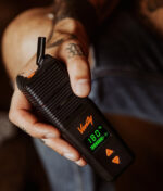 Der Venty Vaporizer in der Hand gehalten vor dunklem Hintergrund