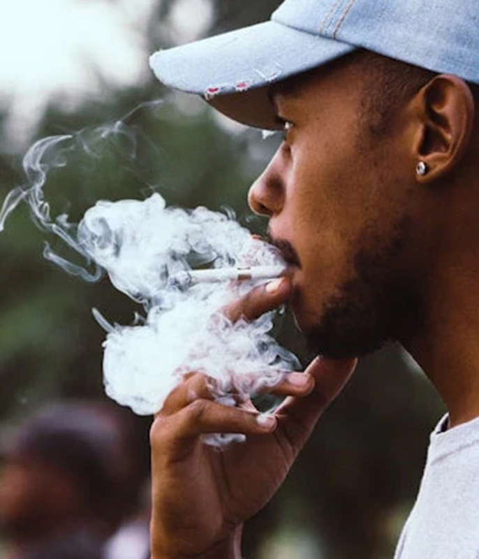 Person raucht King Palm Blunt, dichter Rauch steigt in die Luft