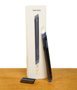 Das limitierte, blaue Puffco Hot Knife Storm vor der Box auf Holz und weißem Hintergrund.