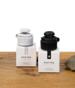 Zwei Puffco Peak Pro Joystick Caps in Schwarz (Onyx) und Weiß (Pearl) auf den jeweiligen Verpackungen