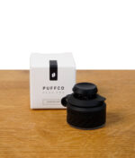 Puffco Peak Pro Joystick Cap in Schwarz (Onyx) neben Verpackung auf Holzuntergrund
