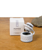 Geöffnete Puffco Peak Pro Joystick Cap in Weiß (Pearl) mit sichtbarem Innenbereich neben Verpackung