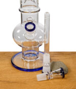 Schlitzdiffusorchillum und Köpfchen mit Farbrand der Glasbong Sojus vor der Bong fotografiert