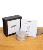 GRIPO 55 Edelstahl Grinder mit schwarzer Box und Garantiekarte auf Holztisch
