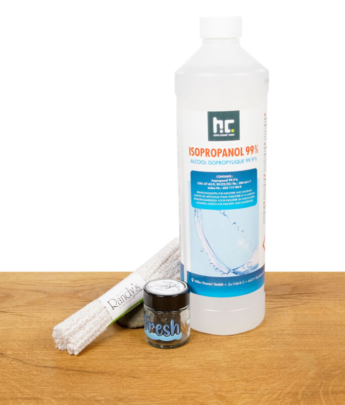 Flasche Isopropanol, Pfeifenreiniger und Glasbehälter mit „Fresh“-Label auf Holz