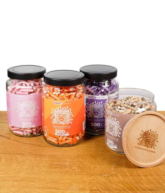 Medusafilters Gläser der Rosé, Sunset, Violet und Organic Edition mit abgenommenem Holzdeckel der Organic Edition im Vordergrund.