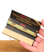 RAW Black Connoisseur Papers geöffnet in der Hand – sichtbar: Tips, Papers und innere Aufdrucke.
