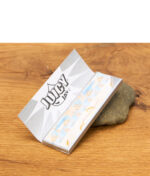 Aufgefaltetes Juicy Jay's Vanilla Ice Paper mit Eiscreme-Print steht vor der Verpackung