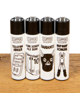 Vier Clipper Feuerzeuge der Serie „Junkie Tattoo“ nebeneinander: Telefon Joker, Mehr Schein als Sein, Raubkatze und HipHop Schere