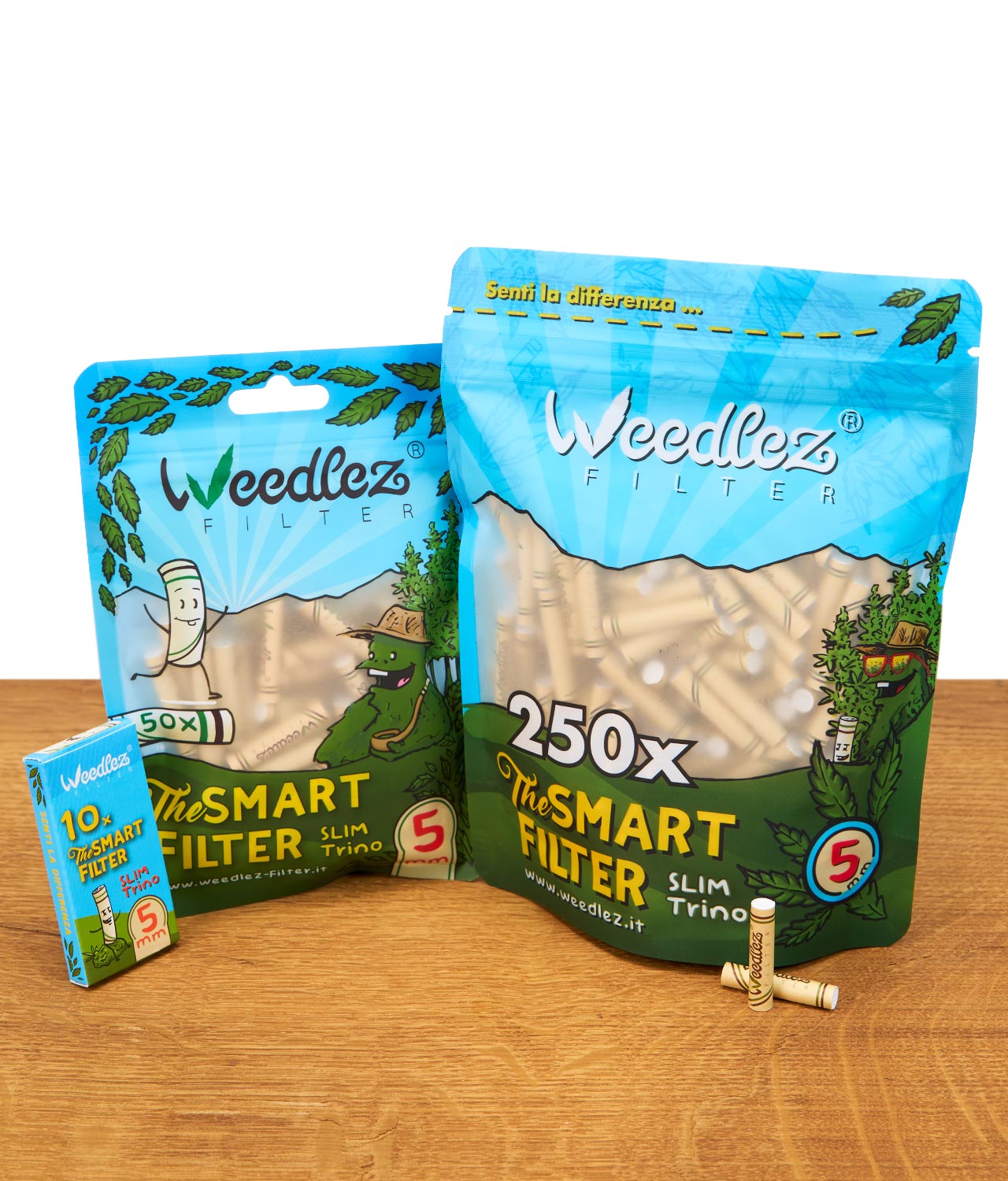 weedlez-smart-filter-slim-trino-5mm-gruppenbild-jpg Gruppenbild der drei Verpackungsgrößen der Weedlez Smart Filter Slim Trino 5 mm: 10er, 50er und 250er auf einem Holztisch.