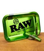 Grüne RAW Rolling Tray 20th Anniversary Edition mit zwei passenden Aluminium Jointtubes auf Holzuntergrund.