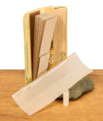 Geöffnete Packung OCB Bamboo Slim mit entfalteten Papers und einem einzelnen vorgedrehten Filter auf einem Stein.