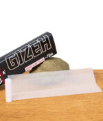 Gizeh King Size Slim +Tips mit abgewickeltem Paper und gerolltem Tip auf Stein präsentiert