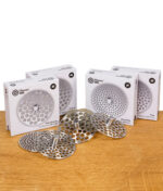 Flower Mill Milling Plates Set in allen vier Varianten (Extra Fine, Fine, Coarse, Extra Coarse) mit Verpackung auf Holzoberfläche.