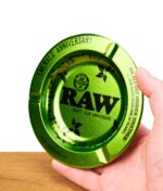 Hand hält Jubiläums-Edition des RAW Emerald Aschenbecher