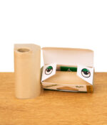 Geöffnete Verpackung mit brauner Roll-Papierrolle und auffälligen Augen-Motiven auf dem Karton, Produkt auf Holzfläche.