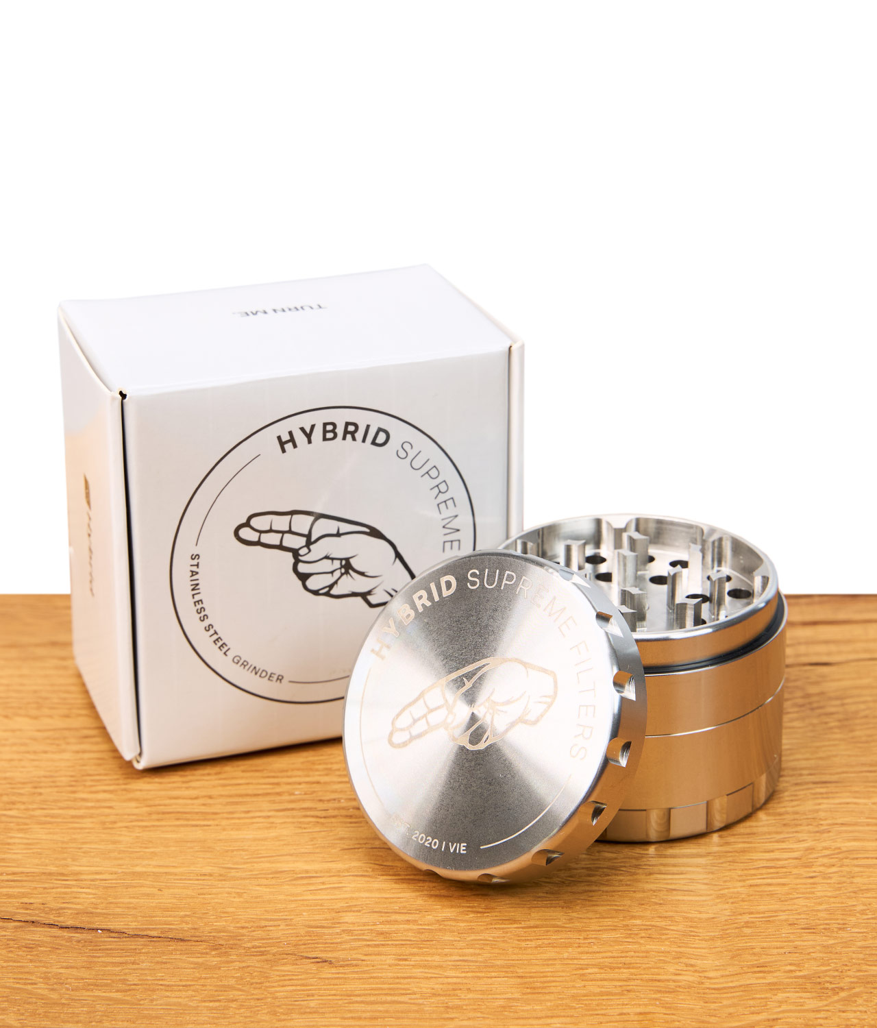 hybrid-edelstahl-grinder-1-jpg Edelstahl Grinder von Hybrid neben Verpackung auf Holz