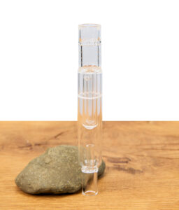 Transparenter Arizer Bubbler Glasmundstück-Aufsatz stehend auf einem flachen Stein und Holztisch, passend für Arizer Air und Solo.