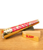 RAW Ethereal Bundle mit goldener RAW Cone-Transporthülle und Classic Tips, Set für Rolling Papers auf Holzplatte.