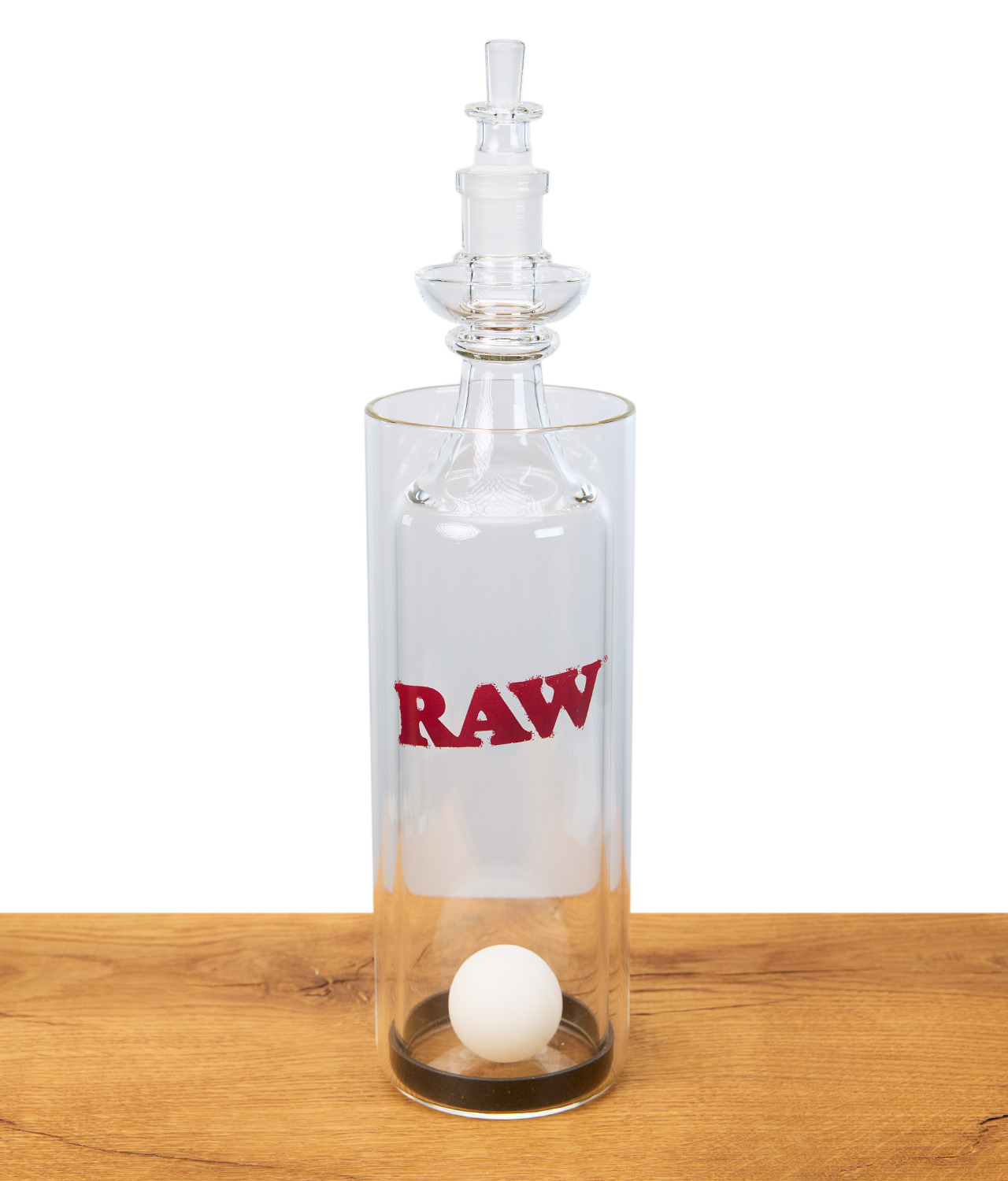 raw-gravity-cone-1-jpg RAW Gravity Cone aus Glas mit Logo, Pingpong-Ball im Inneren, stehend auf Holztisch, Studioaufnahme.