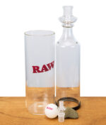 RAW Gravity Cone Einzelteile auf Holztisch: Glasteile, Logo-Zylinder, Pingpong-Ball und weitere Komponenten.