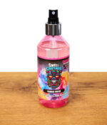 Smell Crusher Fabric Fresh Textilparfüm und Geruchsentferner, pinke Sprühflasche mit buntem Etikett stehend auf Holztisch, freigestellt.