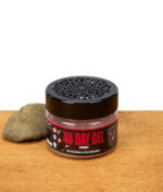 Smell Crusher 40 Day Gel Cherry Lufterfrischer im Glasbehälter mit schwarzem Deckel und Stein, Produktfoto auf Holztisch.