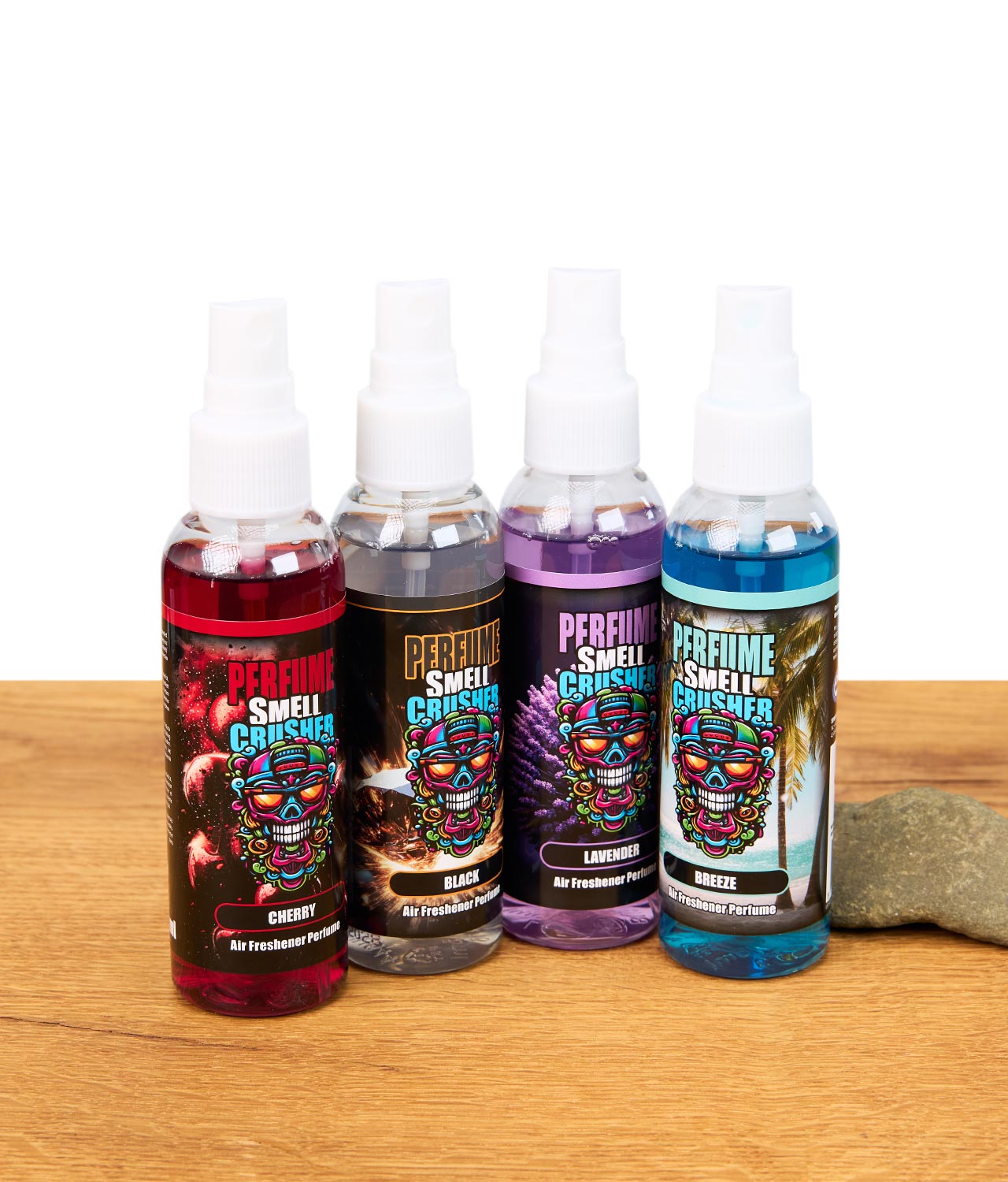smell-crusher-perfume-gruppenbild-jpg Vier verschiedene Smell Crusher Perfume Lufterfrischer Sprays in den Sorten Cherry, Black, Lavender und Breeze, stehend auf Holztisch mit Steinen.