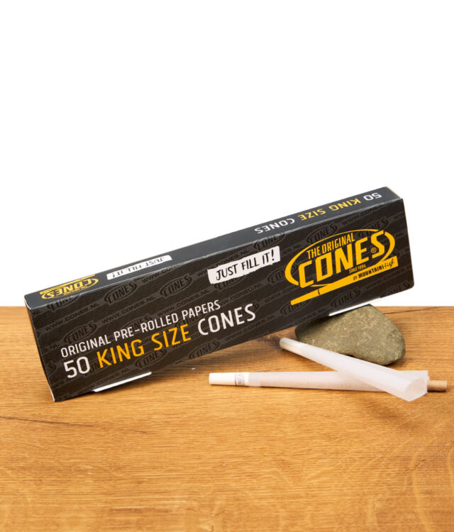Zwei The Original Cones King Size vorgedrehte Papers vor schwarzer Box auf Stein und Holztisch, perfekte Joints in Sekunden
