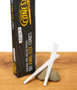 The Original Cones King Size 50er Pack, Box mit vorgedrehten Blättchen und zwei Cones auf Stein platziert, ideal für schnelles Drehen