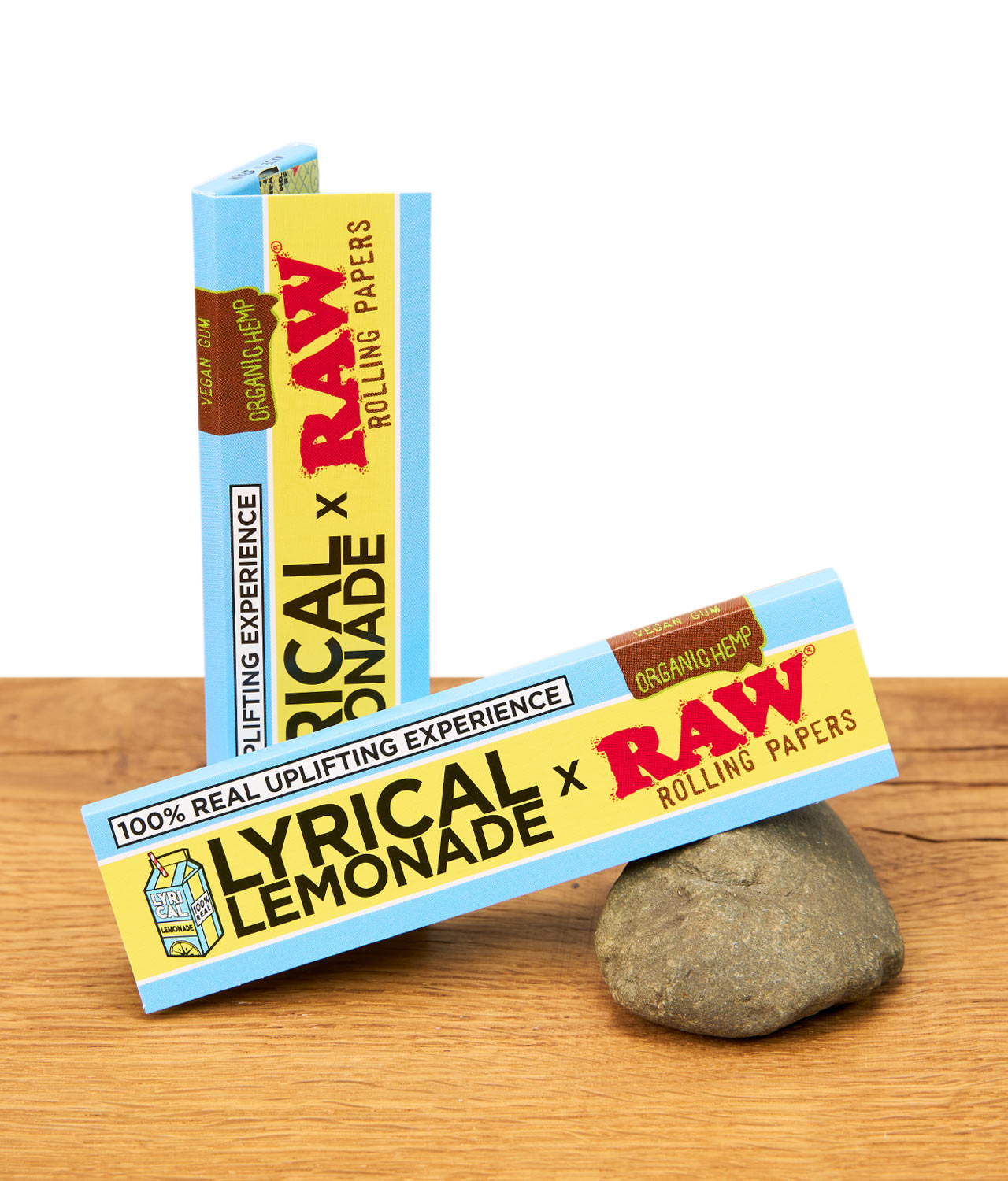 raw-organic-hemp-lyrical-lemonade-paper-jpg RAW x Lyrical Lemonade Rolling Papers mit veganem Gummi und organischem Hanf auf Holztisch, Verpackung im Fokus.