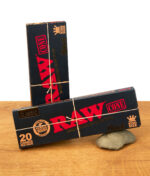 RAW Black King Size Cones 20er Pack, zwei schwarze Verpackungen mit goldener Aufschrift auf Holztisch, natürliche vorgedrehte Drehcones