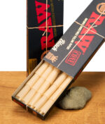 RAW Black King Size Cones 20er Pack, Schachtel mit geöffnetem Deckel zeigt vorgedrehte braune Cones, natürliche ungebleichte Drehpapiere