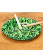Fire Flow Aschenbecher mit Hanfblatt-Muster auf Holztisch, befüllt mit zwei Joints, praktisches Zubehör für Raucher