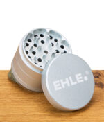 EHLE Keramik Grinder in Silber mit abgenommenem Deckel und sichtbarem Logo, auf Holztisch stehend.