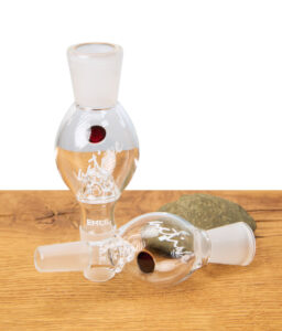 Hand hält EHLE Aktivkohleadapter mit Sieb, rundes Glasteil mit Beschriftung „active“, Adapter für Bong und Wasserpfeife, auf Holztisch.