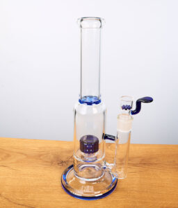 Glasbong mit blauen Farbakzenten und Perkolator auf Holz