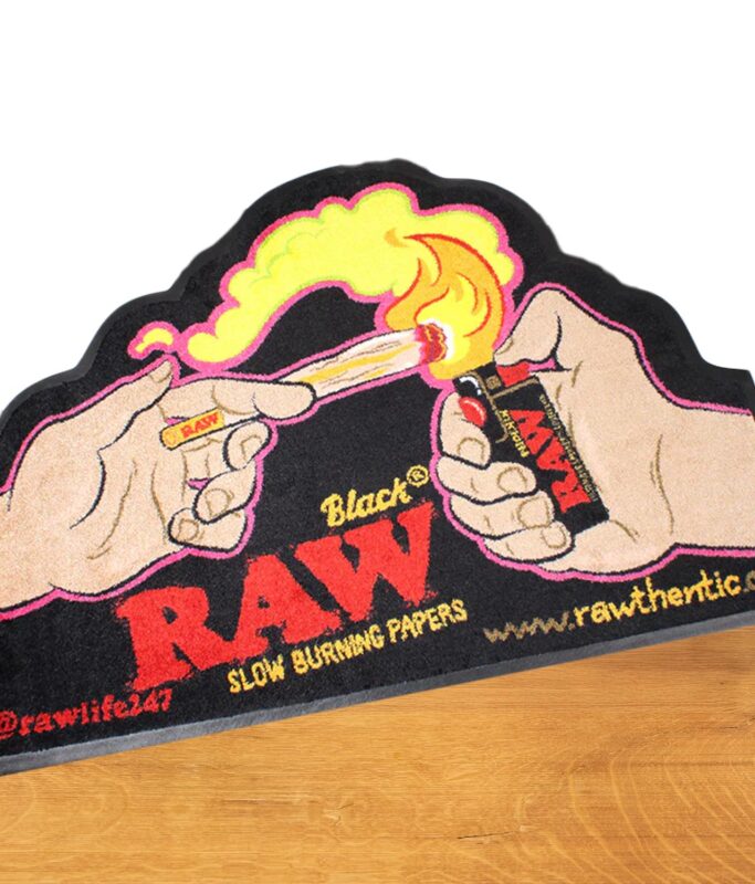Teppich mit buntem Aufdruck von der Marke RAW im "Get Lit" Design mit Hand und Feuerzeug