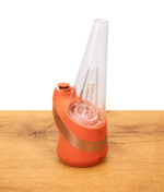 Seitenansicht des Verdampfers "new peak" von Puffco in orangenem "canyon" design auf holz