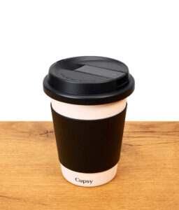 Puffco Cupsy Kaffeebecher Bong in schwarz weiß auf Holz stehend