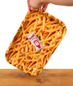 RAW Rolling Tray gehalten von einer Hand mit Pommes Motiv auf einem Holzbrett