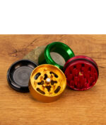 Mehrere Santa Cruz Shredder Grinder 40 mm in verschiedenen Farben aus Aluminium auf Holztisch, teilweise geöffnet