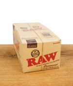 RAW Classic Connoisseur 1 1/4 Papers Box mit Tips auf Holztisch – natürliche ungebleichte Drehpapiere im 24er Display für King Size Joints im Headshop buyhigh.