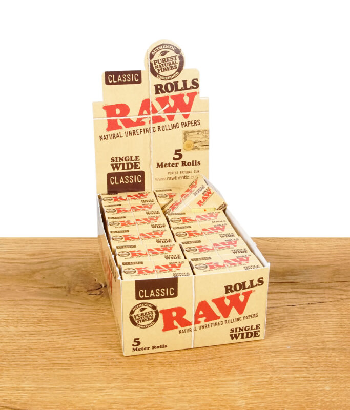 Geöffnete RAW Classic Rolls Single Wide 24er Box auf einem Holztisch, die einzelnen kleinen Packungen sind im Display nach oben hin sichtbar angeordnet.